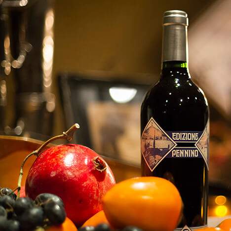 Bottle of Inglenook Pennino with fruit on table.